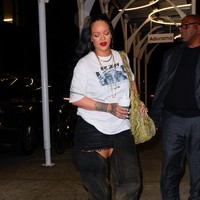 Big is beautiful. Ada saatnya Rihanna ingin berbusana tertutup. Pilihannya pun jatuh pada oversized graphic shirt, rok mini, dan high-knee boots. (Foto: GC Images/Gotham)