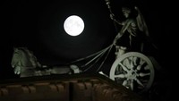 Dari langit Berlin, Jerman, Sturgeon Supermoon juga menebarkan pesonanya dari belakang patung Quadriga di Gerbang Brandenburg, pada 11 Agutus 2022 lalu.
