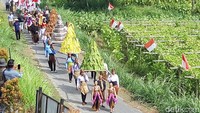 Gunungan dan puluhan bendera itu diarak mulai dari kampung di lereng Gunung Merapi hingga situs cagar budaya Candi Sari. Foto: Jarmaji/detikJateng