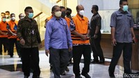 Mereka terlihat mengenakan rompi tahanan KPK berwarna oranye dengan tangan terborgol.