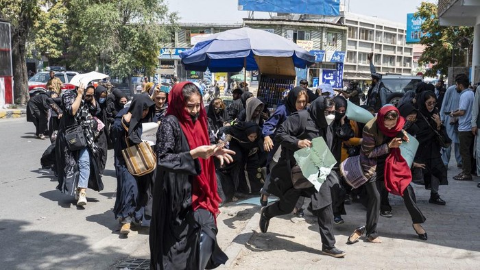Taliban fighters fire into the air to disperse Afghan women protesters in Kabul on August 13, 2022. - Taliban fighters beat women protesters and fired into the air on Saturday as they violently dispersed a rare rally in the Afghan capital, days ahead of the first anniversary of the hardline Islamists return to power. (Photo by Wakil KOHSAR / AFP)