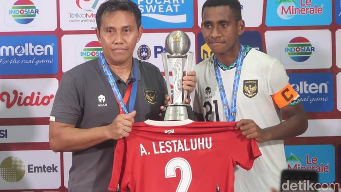 Pelatih Bima Sakti dan kapten Timnas U-16 Indonesia M Iqbal Gwijangge menunjukkan piala AFF U-16 2022 di Stadion Maguwoharjo, Sleman, Jumat (12/8) malam.