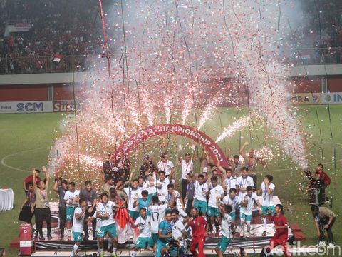 Pelatih Bima Sakti dan kapten Timnas U-16 Indonesia M Iqbal Gwijangge menunjukkan piala AFF U-16 2022 di Stadion Maguwoharjo, Sleman, Jumat (12/8) malam.