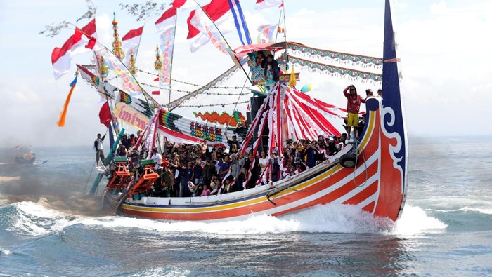 Warga menaiki kapal saat mengikuti prosesi ritual Ritual Petik Laut di Muncar, Banyuwangi, Jawa Timur, Sabtu (13/8/2022). Tradisi turun temurun yang digelar setiap tanggal 15 Muharram sejak tahun 1901 itu merupakan warisan budaya leluhur sebagai ungkapan rasa syukur atas rezeki yang melimpah juga berharap kepada Tuhan Yang Maha Kuasa agar para nelayan diberikan keselamatan dan kemudahan rejeki. ANTARA FOTO/Budi Candra Setya/aww.