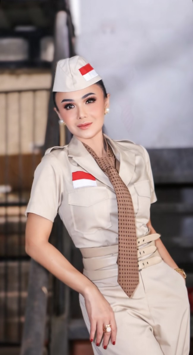 Yuni tampil memesona mengenakan setelan berwarna coklat yang dipadukan dengan ikat pinggang berwarna senada. Baju yang dikenakannya itu memiliki gambar bendera Indonesia merah-putih di bagian kanan atas sakunya. Foto: Instagram/@yunishara36