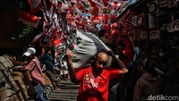 Seorang pria membawa karung besar berisi belanjaan. Gimana detikers, kamu belanja di sini juga untuk menyambut HUT RI?