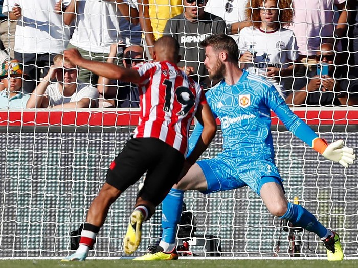 Brentford's French midfielder Bryan Mbeumo (C) shoots past Manchester United's Spanish goalkeeper David de Gea to score their fourth goal during the English Premier League football match between Brentford and Manchester United at Brentford Community Stadium in London on August 13, 2022. - - RESTRICTED TO EDITORIAL USE. No use with unauthorized audio, video, data, fixture lists, club/league logos or 'live' services. Online in-match use limited to 120 images. An additional 40 images may be used in extra time. No video emulation. Social media in-match use limited to 120 images. An additional 40 images may be used in extra time. No use in betting publications, games or single club/league/player publications. (Photo by Ian Kington / AFP) / RESTRICTED TO EDITORIAL USE. No use with unauthorized audio, video, data, fixture lists, club/league logos or 'live' services. Online in-match use limited to 120 images. An additional 40 images may be used in extra time. No video emulation. Social media in-match use limited to 120 images. An additional 40 images may be used in extra time. No use in betting publications, games or single club/league/player publications. / RESTRICTED TO EDITORIAL USE. No use with unauthorized audio, video, data, fixture lists, club/league logos or 'live' services. Online in-match use limited to 120 images. An additional 40 images may be used in extra time. No video emulation. Social media in-match use limited to 120 images. An additional 40 images may be used in extra time. No use in betting publications, games or single club/league/player publications. (Photo by IAN KINGTON/AFP via Getty Images)
