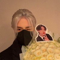 Di sebuah foto, Hakken berpose dengan sebuah karangan mawar putih yang dihiasi foto wajahnya. (Foto: Instagram/@_hakkencoser_)