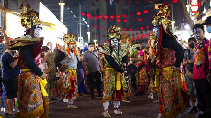 Malaysia Hungry Ghost Festival Ethnic Chinese throw paper offerings during burning of a giant paper statue of the Chinese deity