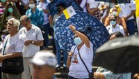 Cuaca yang panas membuat para jemaat memakai payung dan handuk kecil untuk menutupi kepala mereka. Gereja Katolik di Nikaragua telah menjadi sasaran 190 serangan dan penodaan, termasuk kebakaran di Katerdal Mangaua serta pelecehan dan penganiayaan polisi terhadap uskup dan imam.