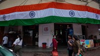 Bendera India sudah mulai terpasang di dinding salah satu toko untuk memperingati 75 tahun kejayaan India merdeka yang progresif, di Dadar, pada Sabtu (13/8/2022) di Mumbai, India. (Satish Bate/Getty Images)
