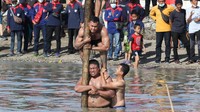 Peserta mengikuti lomba panjat pinang di THP Kenjeran Surabaya, Jawa Timur. Pemkot Surabaya menggelar beragam lomba yang diikuti seluruh jajaran Organisasi Perangkat Daerah (OPD) Pemkot Surabaya, TNI dan Polri serta masyarakat. ANTARA FOTO/Didik Suhartono