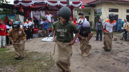 Sejumlah peserta yang menggunakan helm mengikuti lomba balap karung dalam rangka menyambut HUT ke-77 Kemerdekaan RI di halaman Kelurahan Langkai, Palangka Raya, Kalimantan Tengah, Sabtu (13/8/2022). Berbagai ragam lomba unik mulai digelar di kota tersebut untuk menyemarakkan HUT ke-77 Kemerdekaan Republik Indonesia sekaligus dalam upaya menjaga serta mempererat kerukunan antarwarga. ANTARA FOTO/Makna Zaezar/nym.