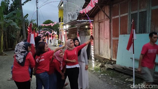 Warga selfie di deretan gerbang lampu merah putih yang menghiasi Dusun Gunung Gempal, Kalurahan Giripeni, Kapanewon Wates, Kulon Progo, Sabtu (13/8/2022)