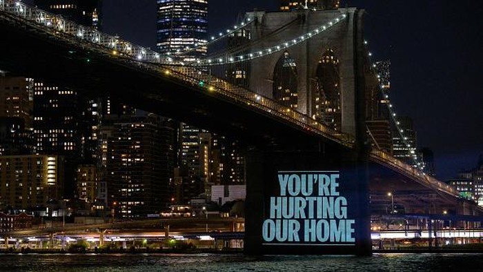 Aksi Greenpeace Serukan Pesan Untuk PBB di Bawah Jembatan Brooklyn NEW YORK, NEW YORK - AUGUST 14: People gather around to watch as Greenpeace activists illuminate the Brooklyn Bridge with projections of the ocean and messages that read,