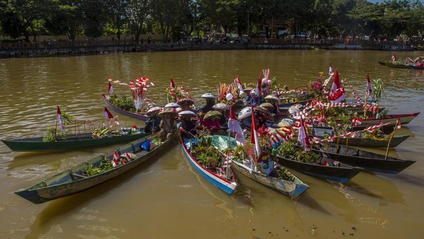 Pedagang pasar terapung menawarkan dagangannya dari atas perahu (jukung) saat Festival Budaya Pasar Terapung di Sungai Martapura, Banjarmasin, Kalimantan Selatan, Senin (15/8/2022).   