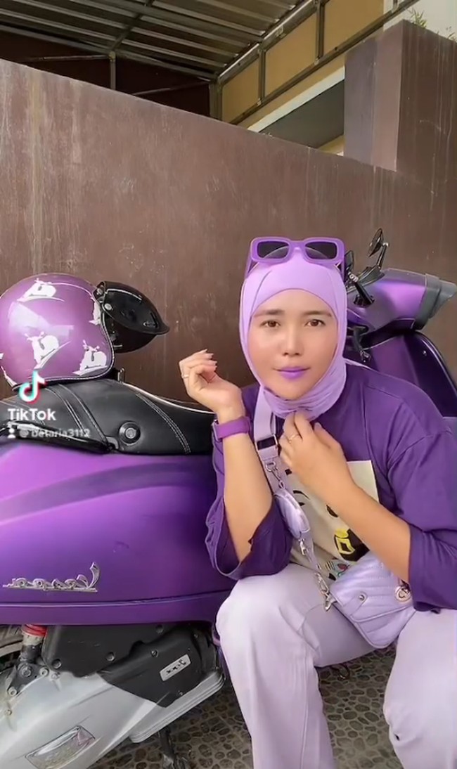 Wanita yang merupakan fans warna ungu itu merekam dirinya sendiri bersama motor, helm dan kacamata yang serba ungu. Ia bahkan memakai lipstick, hijab, kaus, dan sling bag ungu. Dia mengunggah video aksinya itu lewat lewat akun TikToknya @betaria3112. Gagal😫 helm nya pake jatoh🫣ig betaria_87, tulis wanita bernama Beta Ria lewat akun TikTok @betaria3112. Foto: Dok. Instagram @betaria_87.