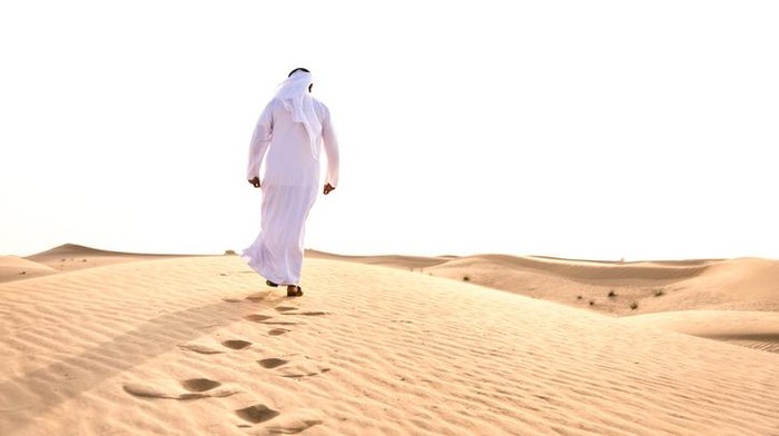 arabic man praying in the desert