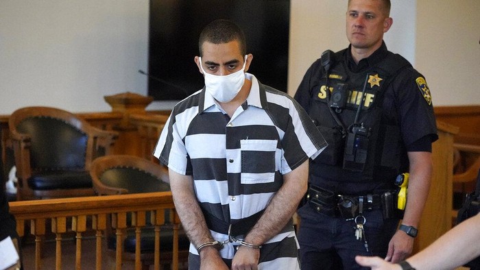 Hadi Matar, 24, center, arrives for an arraignment in the Chautauqua County Courthouse in Mayville, N.Y., Saturday, Aug. 13, 2022. Matar, who is accused of carrying out a stabbing attack against “Satanic Verses” author Salman Rushdie has entered a not-guilty plea in a New York court on charges of attempted murder and assault. An attorney for Matar entered the plea on his behalf during an arraignment hearing.  (AP Photo/Gene J. Puskar)