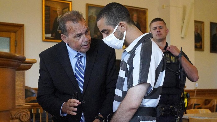 Hadi Matar, 24, center, arrives for an arraignment in the Chautauqua County Courthouse in Mayville, N.Y., Saturday, Aug. 13, 2022. Matar, who is accused of carrying out a stabbing attack against “Satanic Verses” author Salman Rushdie has entered a not-guilty plea in a New York court on charges of attempted murder and assault. An attorney for Matar entered the plea on his behalf during an arraignment hearing. (AP Photo/Gene J. Puskar)