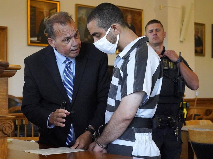 Hadi Matar, 24, center, arrives for an arraignment in the Chautauqua County Courthouse in Mayville, N.Y., Saturday, Aug. 13, 2022. Matar, who is accused of carrying out a stabbing attack against “Satanic Verses” author Salman Rushdie has entered a not-guilty plea in a New York court on charges of attempted murder and assault. An attorney for Matar entered the plea on his behalf during an arraignment hearing.  (AP Photo/Gene J. Puskar)