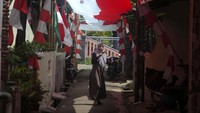 Warga melintas dibawah bendera merah putih terpanjang di Desa Pekauman Kulon, Kabupaten Tegal, Jawa Tengah, Senin (15/8/2022).