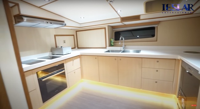 Sementara di sisi sebelahnya terdapat ruangan dapur yang cukup luas dengan didominasi warna coklat. Dapur tampak cukup lengkap dengan kompor, oven, tempat cuci piring, dan lemari-lemari untuk menyimpan barang-barang dapur. Foto: YouTube/Leslar Entertainment