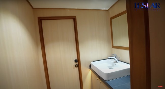 Di bagian depan kamar mandinya terdapat wastafel dan sebuah kaca. Sama seperti ruangan dapur dan kamar, ruangan kamar mandinya pun didominasi oleh warna coklat. Foto: YouTube/Leslar Entertainment