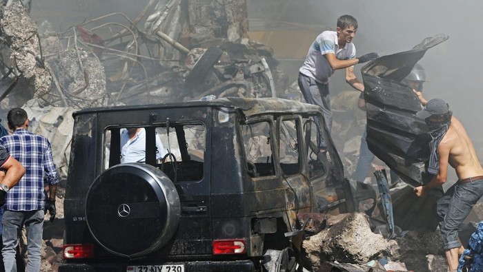 People clear the debris after blasts ripped through a fireworks warehouse in a shopping mall in Yerevan, Armenia August 14, 2022. Vahram Baghdasaryan/Photolure via REUTERS ATTENTION EDITORS - THIS IMAGE HAS BEEN SUPPLIED BY A THIRD PARTY.