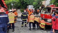 Mobil derek beraksi mengevakuasi mobil PMK yang terguling/Foto: Esti Widiyana/detikJatim