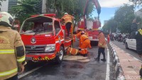 Mobil derek beraksi mengevakuasi mobil PMK yang terguling/Foto: Esti Widiyana/detikJatim