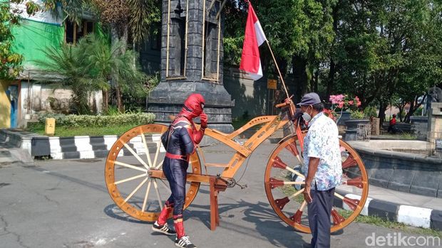 Sarijo dengan kostum Spiderman naik sepeda kayu raksasa keliling kota Klaten, Senin (15/8/2022).