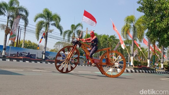 Sarijo dengan kostum Spiderman naik sepeda kayu raksasa keliling kota Klaten, Senin (15/8/2022).