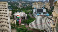 Harsdeep Pawar, seorang pria dari Tim Slackistan yang melakukan aksi dengan cara berjalan di tali yang diikat di antara gedung perkotaan di Mumbai, India, Senin (15/8/2022). Aksi tersebut berada di ketinggian 83 meter. (Pratik Chorge/Getty Images)