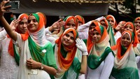 Siswi sekolah dan Perguruan Tinggi Anjuman-E-Islam mengenakan kerudung menyerupai warna bendera India untuk merayakan Hari Kemerdekaan ke-75, di CSMT, Mumbai, India. (Anshuman Poyrekar/Getty Images)