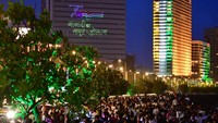 Warga India berkerumun di Marine Drive, Mumbai, India pada hari kemerdekaan 15 Agustus. Terlihat Gedung tinggi menampilkan lampu-lampu tulisan dan tiga warna bendera India untuk memperingati kemerdekaan yang ke-75 tahun (Bhushan Koyande/Getty Images)