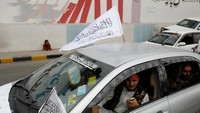 Pendukung Taliban berkonvoi menggunakan mobil sambil membawa bendera Imarah Islam Afghanistan.