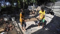 Anak laki-laki Palestina membawa bejana tanah liat untuk dikeringkan.