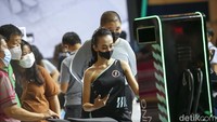 Seorang usher event memberi penjelasan tentang kendaraan listrik kepada pengunjung.