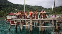 Anak-anak sekolah menunggu kedatangan perahu motor atau pompong di Desa Telaga Besar, Kabupaten Kepulauan Anambas, Kepulauan Riau (Kepri), Rabu (3/8/2022). Operator perahu pompong tidak memungut biaya alias gratis, khusus untuk antar-jemput siswa ke sekolah.