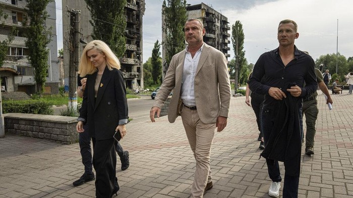 Mantan Bintang Sepakbola Andriy Shevchenko Kunjungi Borodianka, Ukraina Former striker and coach of the Ukraine national soccer team Andriy Shevchenko, right, and American actor Liev Schreiber, centre, walk on the street in front of a house which have been destroyed by Russia bombardment in Borodianka, near Kyiv, Ukraine, on Monday, Aug. 15, 2022. (AP Photo/Evgeniy Maloletka)