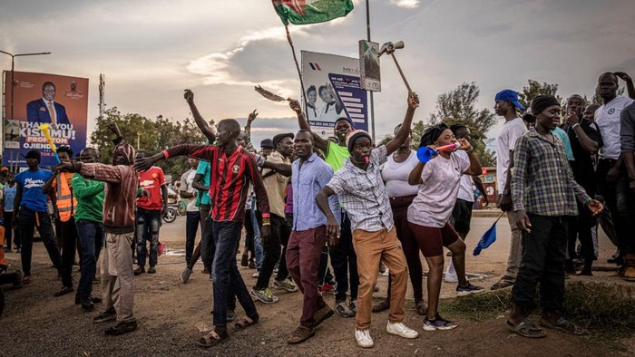 KISUMU, KENYA - AUGUST 15: People protest amid tear gas fired by Kenyan police after election results were announced on August 15, 2022 in Kisumu, Kenya. Some protesters could be heard shouting No Raila, no peace as they threw stones and looted shops in one of Raila Odingas main political strongholds. On August 9, 65% of 22.1 million eligible voters in Kenya voted six times to determine the political future of their country. It was a tight race between presidential candidates Raila Odinga, aged 77, a veteran of the opposition, and Kenya's vice-president, William Ruto, aged 55. (Photo by Ed Ram/Getty Images)