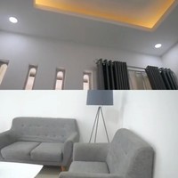 Masuk ke dalam ruang tamu bernuansa putih dan abu-abu. Terdapat tanaman hias jenis Monstera Diliciosa. Sofa ruang tamu berwarna abu-abu gelap. Foto: Dok. Youtube Zhiee Leely.