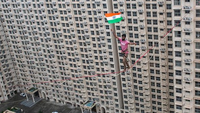 MUMBAI, INDIA  AUGUST 15: Harsdeep Pawar of Team Slackistan walks on the highline rigged at a height of approximately 250 feet with the Indian Tricolour in his hand as part of the 