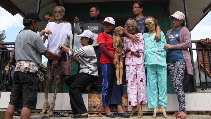 Kerabat memasukkan kembali jenazah keluarganya ke dalam peti saat ritual Manene di Lembang Ampang Batu, Kabupaten Toraja Utara, Sulawesi Selatan, Senin (15/8/2022). Ritual yang digelar secara turun temurun oleh masyarakat Toraja tersebut untuk mengganti dan membersihkan jenazah keluarga sebagai bentuk penghormatan dan kasih sayang terhadap leluhur mereka. ANTARA FOTO/Arnas Padda/wsj.