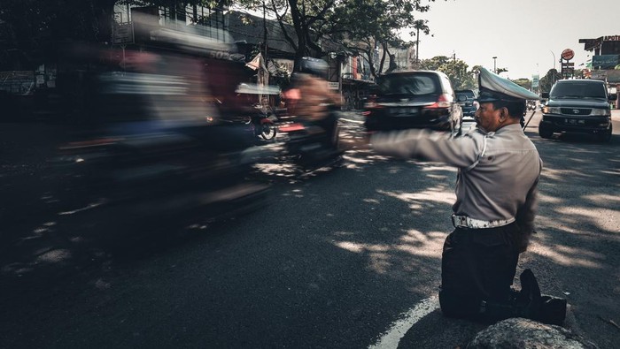 Ahmad Junaedi mengatur lalu lintas di persimpangan Jalan Ciledug Raya dan Jalan Gotong Royong, Larangan, Tangerang, Banten.