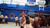 Marketing dan Analisis Mikro atau Mantri BRI, Fremar Refel Welang, menyambut anak-anak SDN 006 Telaga Kecil di depan Teras BRI Kapal di Pulau Telaga Kecil, Kabupaten Kepulauan Anambas, Kepulauan Riau.