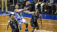 Pebasket Prawira Bandung Yudha Saputera (tengah) melakukan lay up shoot dibayangi pebasket Dewa United Surabaya Xaverius Prawiro (kiri) dan Kevin M Eliazer Poetiray (kanan).