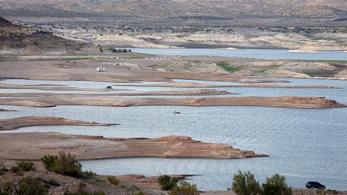 Waduk Terbesar di Meksiko Makin Mengering, Begini Penampakannya TRUTH OR CONSEQUENCES, NEW MEXICO - AUGUST 15: People walk on a jetty beneath a 'bathtub ring' of mineral deposits left by higher water levels at the drought-stricken Elephant Butte Reservoir on August 15, 2022 near Truth or Consequences, New Mexico. New Mexico’s largest reservoir is currently at 3.8 percent of its total capacity in spite of recent monsoon rains in the state. According to officials, water levels at Elephant Butte have been below average since around 2019 and the lake has not been able to meet full levels of irrigation demand for several years. Experts say that in spite of the monsoon rains bringing temporary relief to parts of the Southwest, the climate change-fueled megadrought remains entrenched in the West. (Photo by Mario Tama/Getty Images)