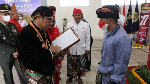 Bupati Tabanan, I Komang Gede Sanjaya, pada sisi kiri dan mengenakan baju adat Yogyakarta saat menyerahkan remisi 17 Agustus kepada salah satu perwakilan napi di LP Kelas II B, Rabu (17/8/2022).